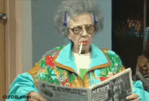 An Elderly Woman Smoking A Cigarette While Reading A Newspaper . GIF