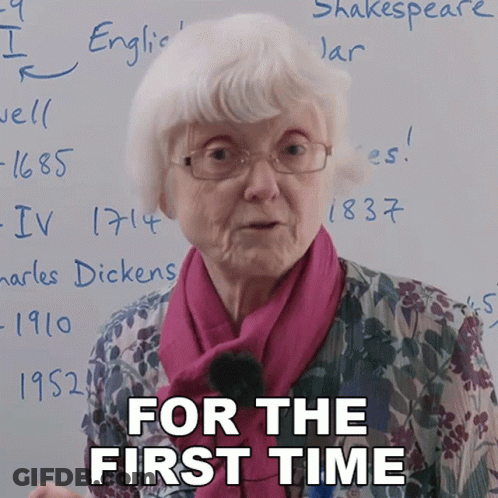 An Elderly Woman Stands In Front Of A White Board With The Words " For The First Time " Written On It GIF