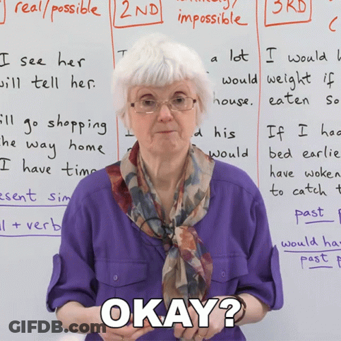 An Elderly Woman Stands In Front Of A Whiteboard With Okay Written On It GIF