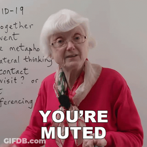 An Elderly Woman Stands In Front Of A Whiteboard With The Words " You 'Re Muted " On It GIF