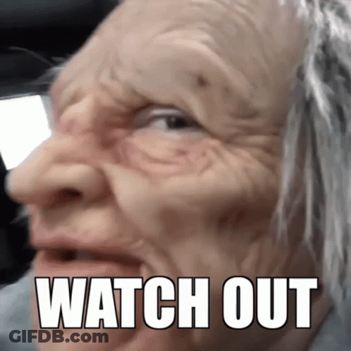 An Elderly Woman Wearing A Mask With The Words Watch Out Written On Her Face GIF