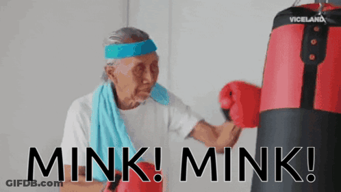 An Elderly Woman Wearing Boxing Gloves And A Headband With The Words Mink Mink On It GIF