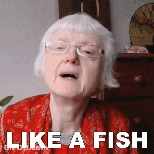 An Elderly Woman Wearing Glasses And A Red Jacket Says Like A Fish GIF