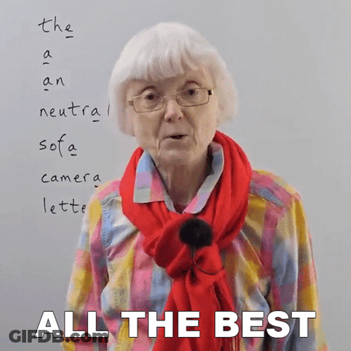 An Elderly Woman Wearing Glasses And A Red Scarf Stands In Front Of A White Board That Says All The Best GIF