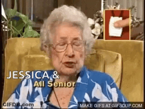 An Elderly Woman Wearing Glasses Is Sitting In A Chair And Talking To Someone . GIF