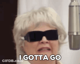 An Elderly Woman Wearing Sunglasses And A Wig Is Standing In Front Of A Microphone . GIF