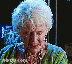 An Elderly Woman With White Hair Is Wearing A Green Sweater GIF