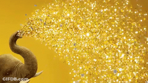 An Elephant 'S Trunk Is Blowing Gold Confetti On A Yellow Background GIF