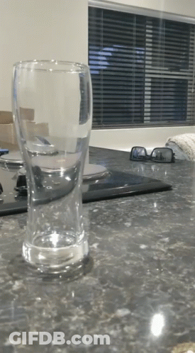 An Empty Glass Sits On A Kitchen Counter Next To A Pair Of Sunglasses GIF