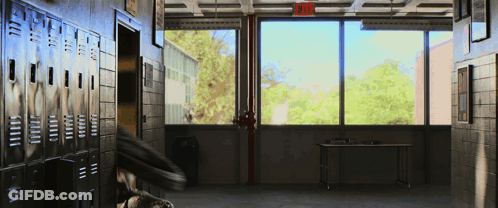 An Empty Hallway With A Red Exit Sign Above The Window GIF