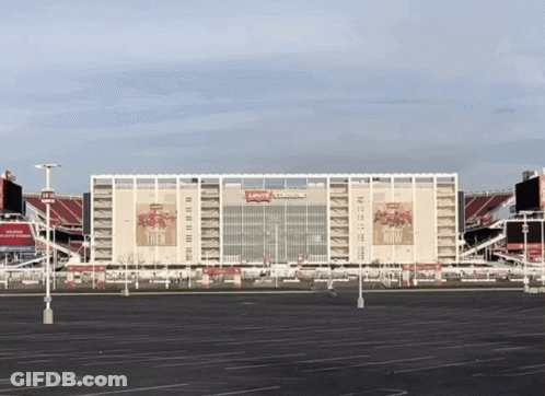 An Empty Parking Lot In Front Of A Large Stadium That Says Levi 'S Stadium GIF