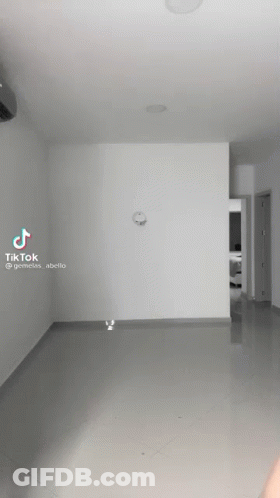 An Empty Room With A Clock On The Wall And A Tiktok Video GIF