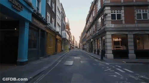 An Empty Street With A Sign That Says Be & Sch GIF
