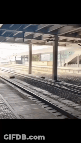 An Empty Train Station With A Few Tracks And A Few Pillars GIF