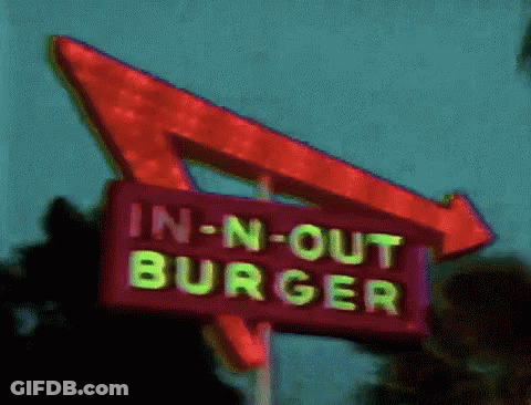 An In-N-Out Burger Sign With A Red Arrow GIF