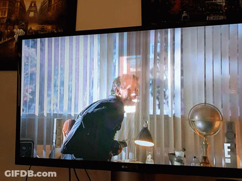 An Lg Tv Shows A Man Hanging Upside Down In A Room GIF