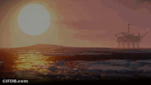 An Oil Rig In The Ocean At Sunset With The Sun Shining Through The Clouds GIF