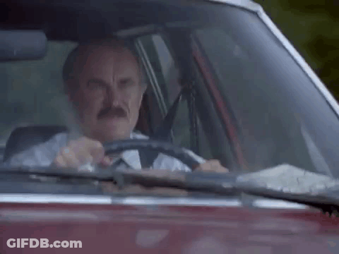 An Old Man Is Driving A Car And Giving The Middle Finger . GIF