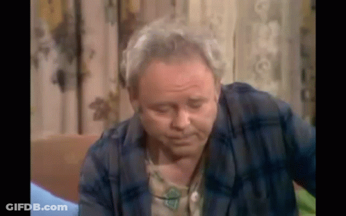 Older Man In Plaid Shirt Sitting On Couch GIF