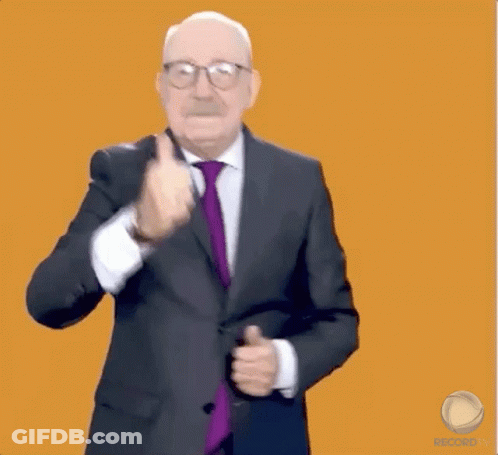 An Older Man In A Suit And Tie Is Dancing In Front Of An Orange Background GIF