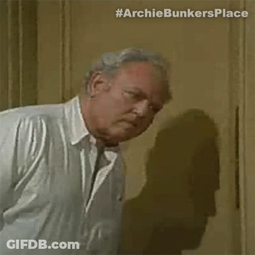 Older Man In White Shirt And Tie Standing By Door GIF