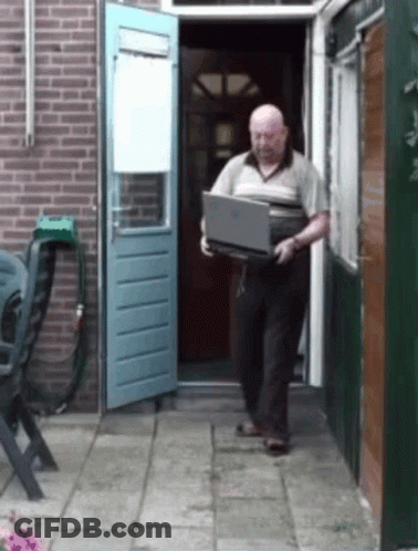 An Older Man Is Carrying A Laptop Out Of A House GIF