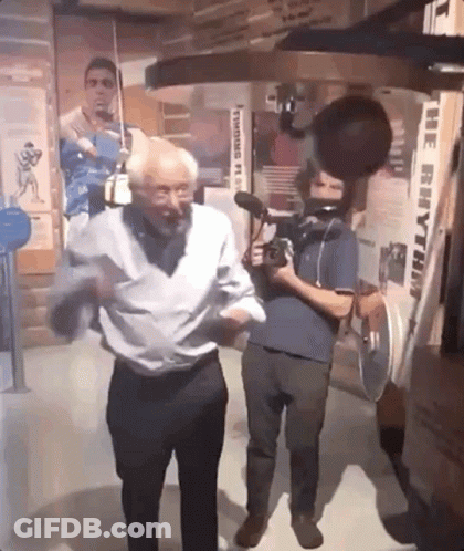 An Older Man Is Dancing In Front Of A Machine That Says The Rhythm GIF