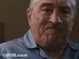 An Older Man Is Making A Funny Face With His Mouth Open And His Eyes Closed . GIF