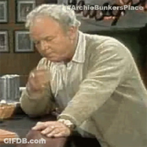 Older Man Looking At Something With Hands On Table GIF