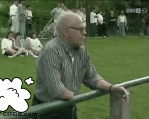 An Older Man Leaning On A Railing In A Park With A Thought Bubble With The Number 3 On It GIF