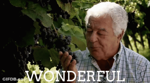 An Older Man Smelling A Bunch Of Grapes With The Word Wonderful Written Below Him GIF