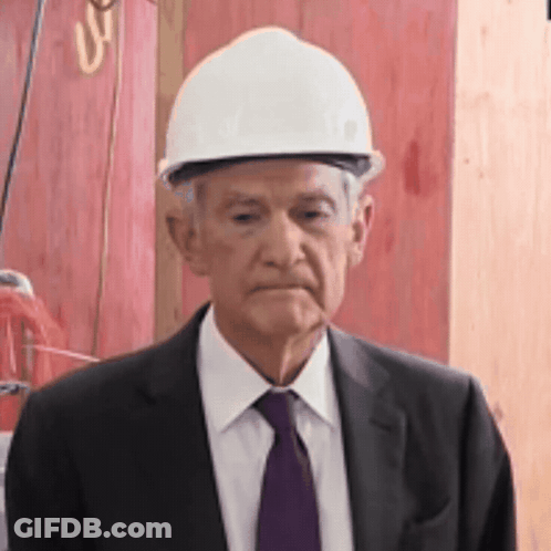 An Older Man Wearing A Hard Hat And Suit GIF