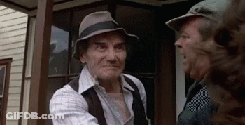 An Older Man Wearing A Hat Is Talking To Another Man GIF