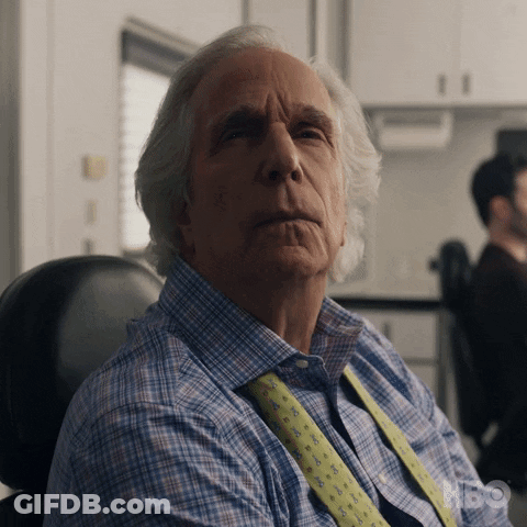 Older Man In Plaid Shirt And Tie Sitting In Chair HBO Shirt GIF