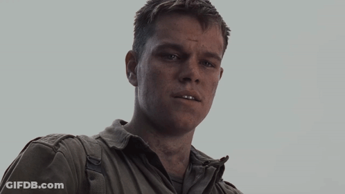 An Older Man Wearing A White Shirt And A Grey Jacket Looks At The Camera GIF