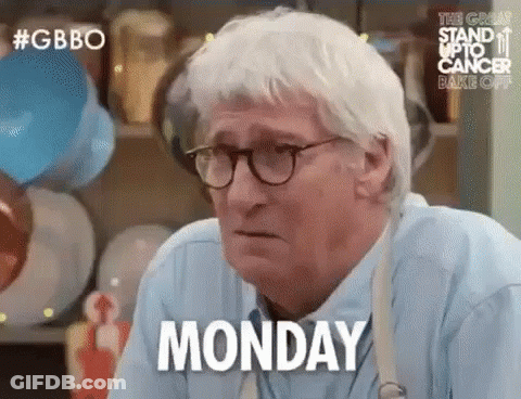 An Older Man Wearing Glasses And A Blue Shirt Is Sitting At A Table . GIF