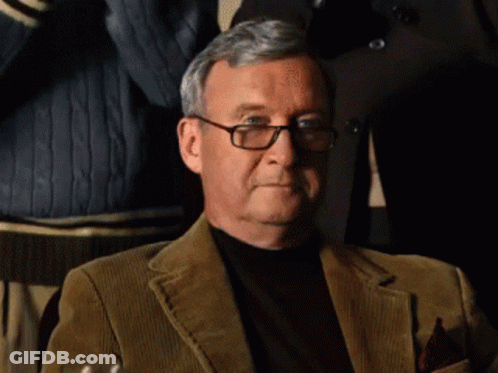 An Older Man Wearing Glasses And A Brown Jacket GIF