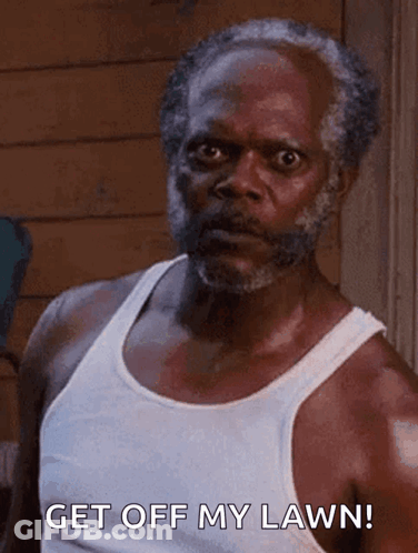 An Older Man With A Beard Is Wearing A White Tank Top And Saying Get Off My Lawn . GIF