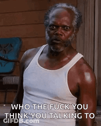 An Older Man With A Beard Is Wearing A White Tank Top And Says Who The Fuck You Think You Talking To . GIF