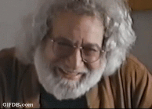 An Older Man With Glasses And A Beard Is Smiling GIF