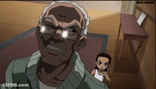 An Older Man With Glasses Is Standing Next To A Younger Man In A Room With A Table . GIF
