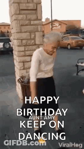 An Older Woman Is Dancing In Front Of A Brick Wall . GIF