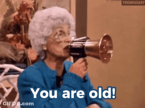 An Older Woman Is Holding A Megaphone In Her Mouth And Says You Are Old GIF