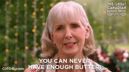 An Older Woman Says " You Can Never Have Enough Butter " In Front Of A Sign For The Great Canadian Baking Show GIF