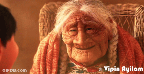 An Older Woman Sitting In A Wicker Chair With The Name Vipin Ayilam On The Bottom GIF