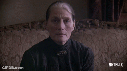 An Older Woman Sitting On A Couch With A Netflix Logo On The Bottom GIF