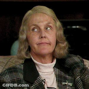 An Older Woman Wearing A Plaid Jacket And A Turtleneck GIF