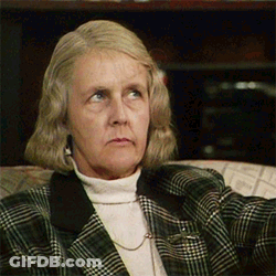 An Older Woman Wearing A Plaid Jacket And A White Turtleneck GIF