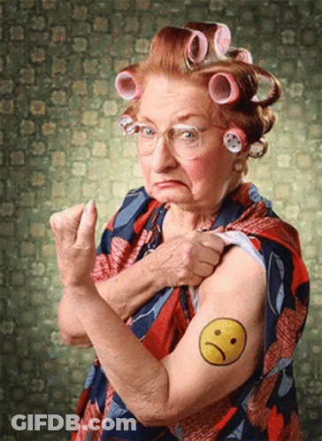 An Older Woman With Curlers On Her Hair Has A Smiley Face Tattooed On Her Arm GIF