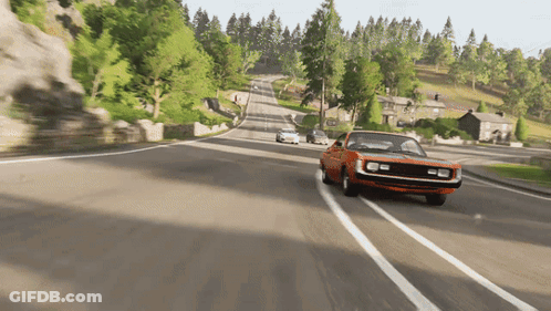 An Orange Car Is Driving Down A Road With Trees On The Side GIF